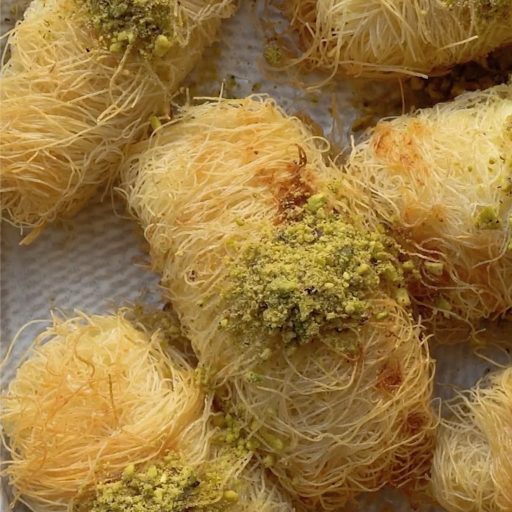 Rhukra Cake House Cheese Kunafa rolls topped with crushed pistachios, featuring a golden crispy shredded pastry