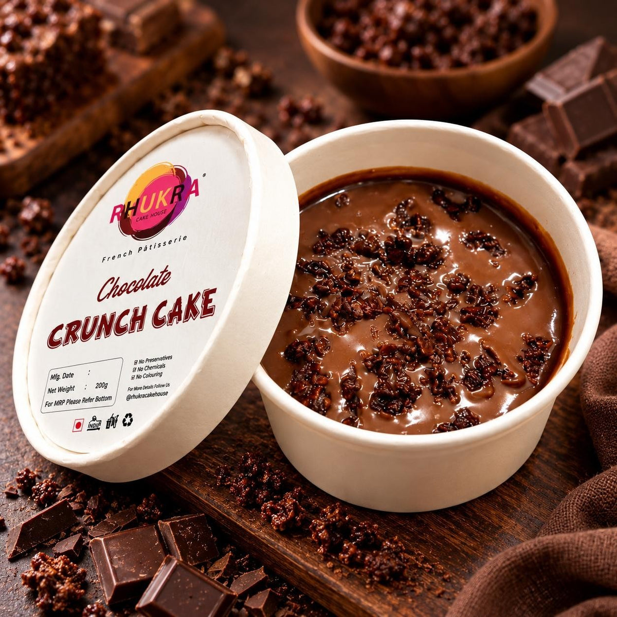 Rhukra Cake House Chocolate Crunch Cake in a white paper cup with chocolate ganache and crunchy toppings
