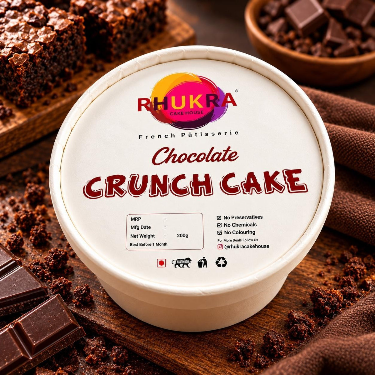 Rhukra Cake House Chocolate Crunchy cake in a round white container with chocolate chunks and brownie pieces
