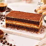 Rhukra Cake House tiramisu dessert with layers of coffee-soaked ladyfingers, creamy mascarpone, and cocoa powder.