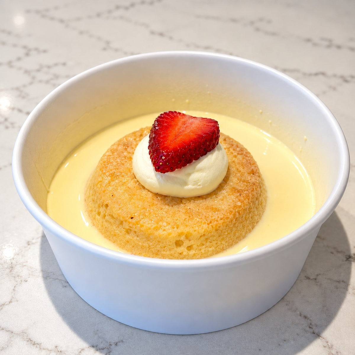 Rhukra Cake House classic Tres leches cake soaked in milk, topped with whipped cream and a fresh strawberry slice.